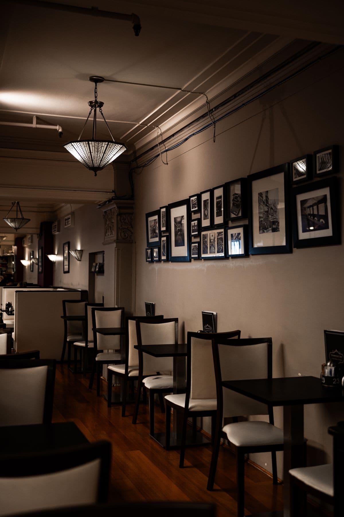Dymocks Cafe dining area with heritage pendant lights and gallery wall
